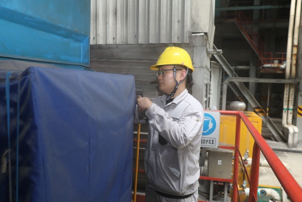 图为运行人员在对户外设备覆盖防雨篷布.JPG