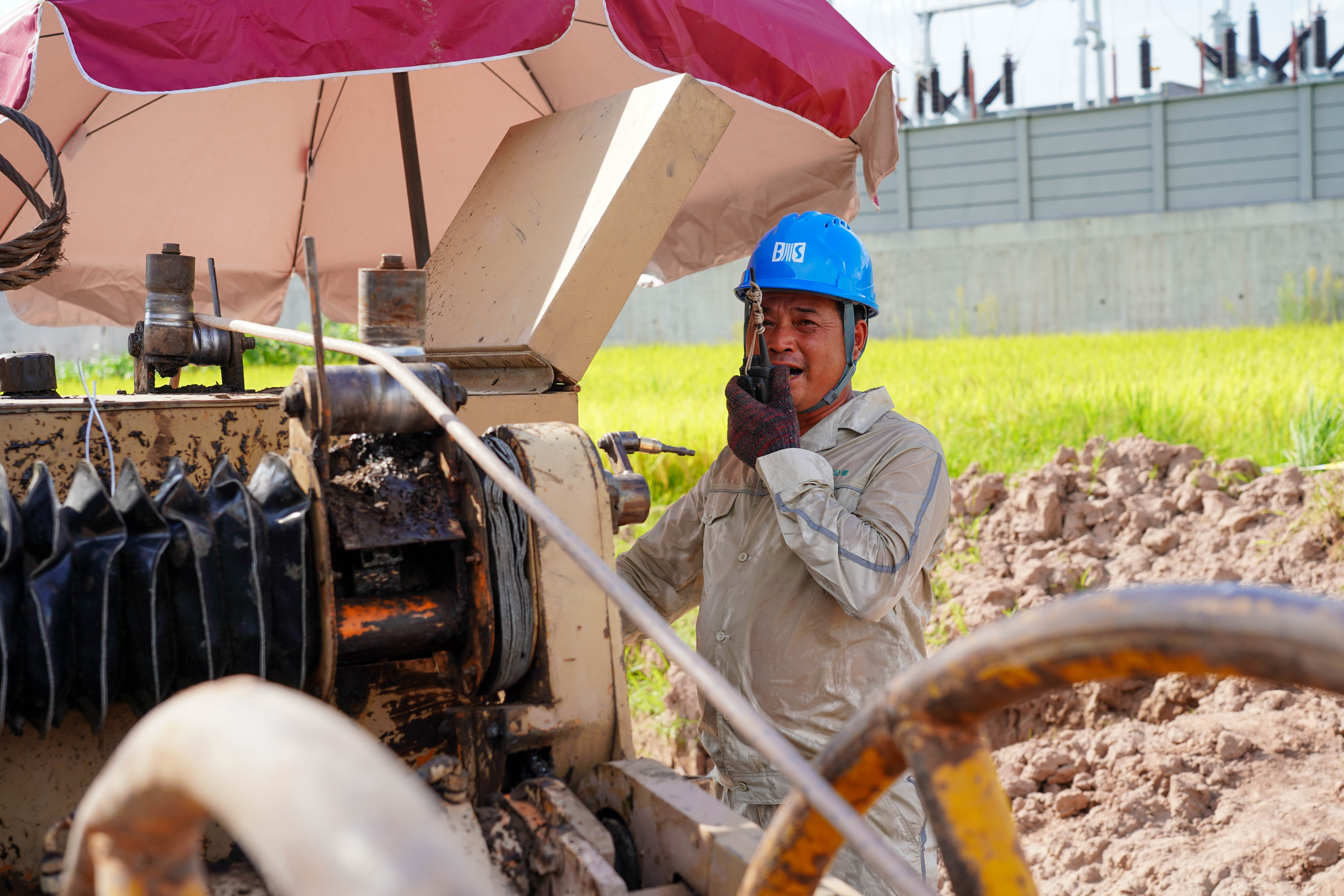 8月26日，国网开州供电公司员工使用对讲机指挥导线展放工作。（潘洪 摄） (1).jpg